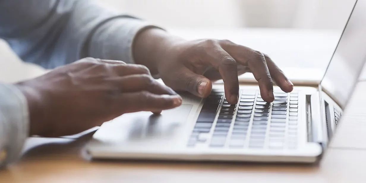 Man Typing on Laptop